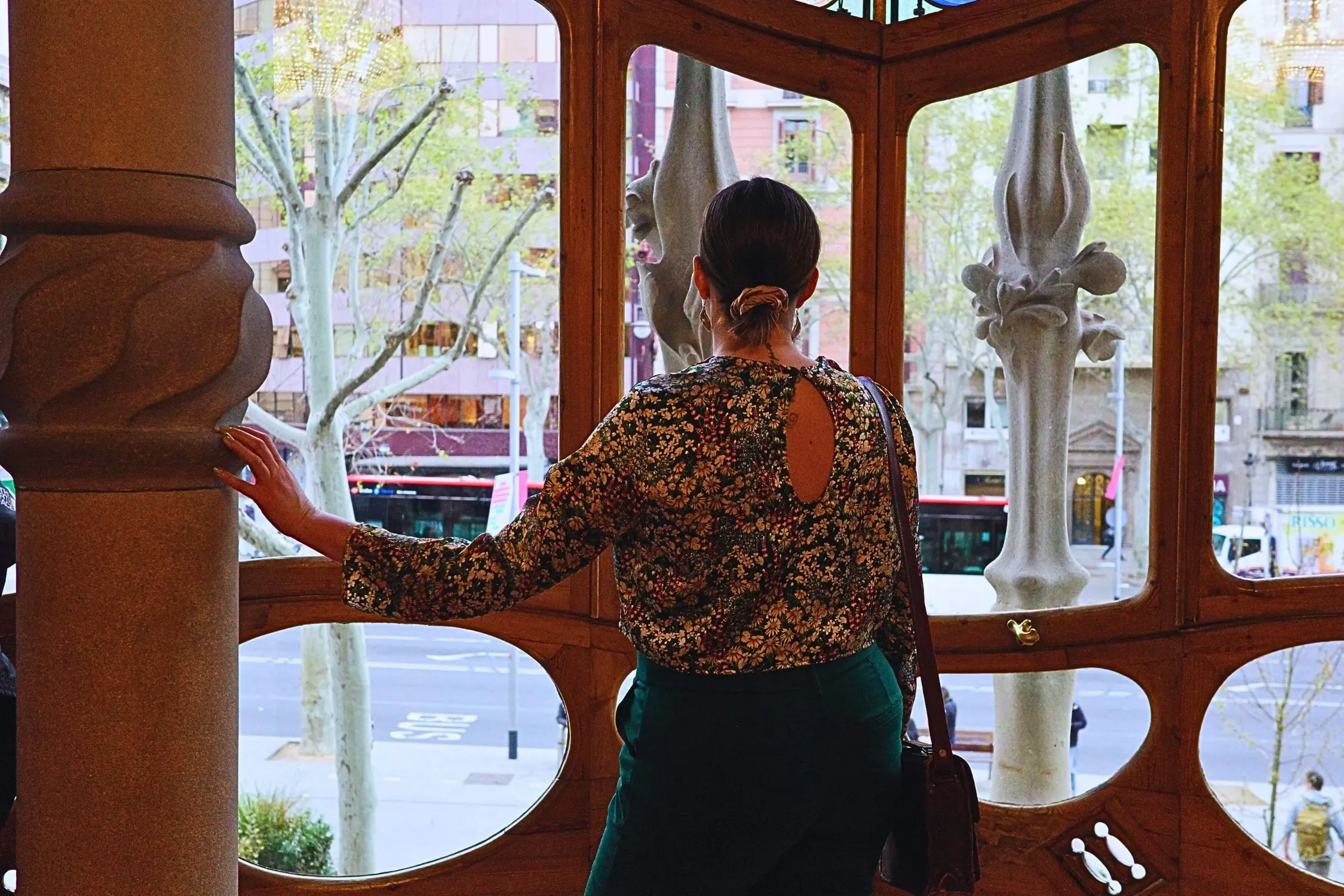 Woman looking outside of window in Casa Batllo in Barcelona during tour