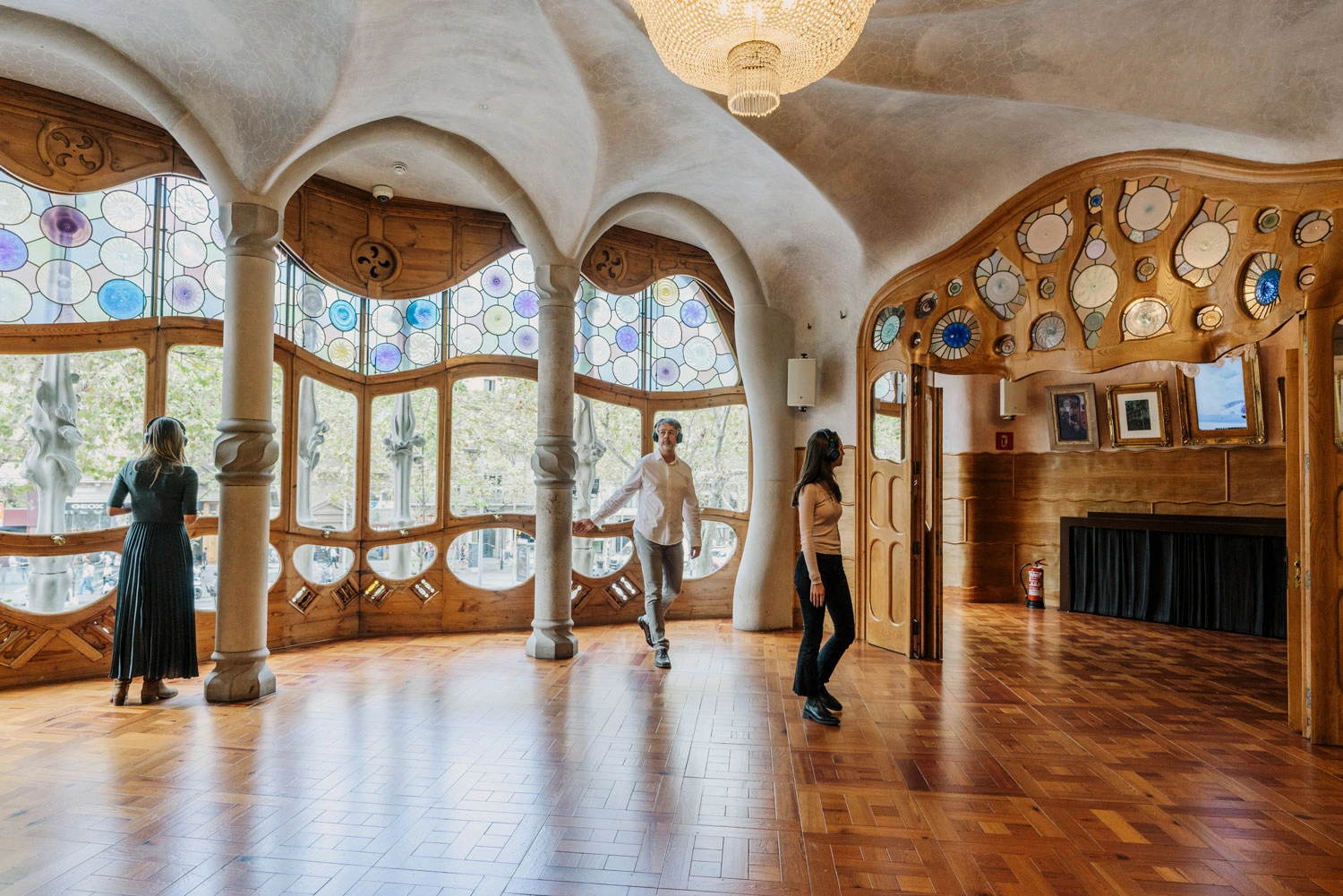 Guests with audio guides observing Casa Batlló during tour